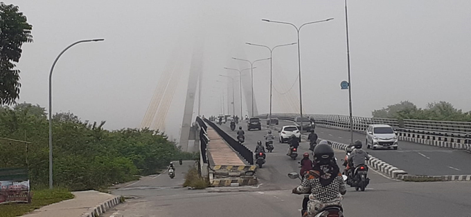 Kabut embun yang memenuhi Kota Pekanbaru pada pagi hari, Jumat (24/6/2022) membuat hilang menara Jembatan Siak 4 Pekanbaru.